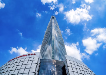 View of Lotte World Tower in Seoul under a bright blue sky, showcasing modern architecture.