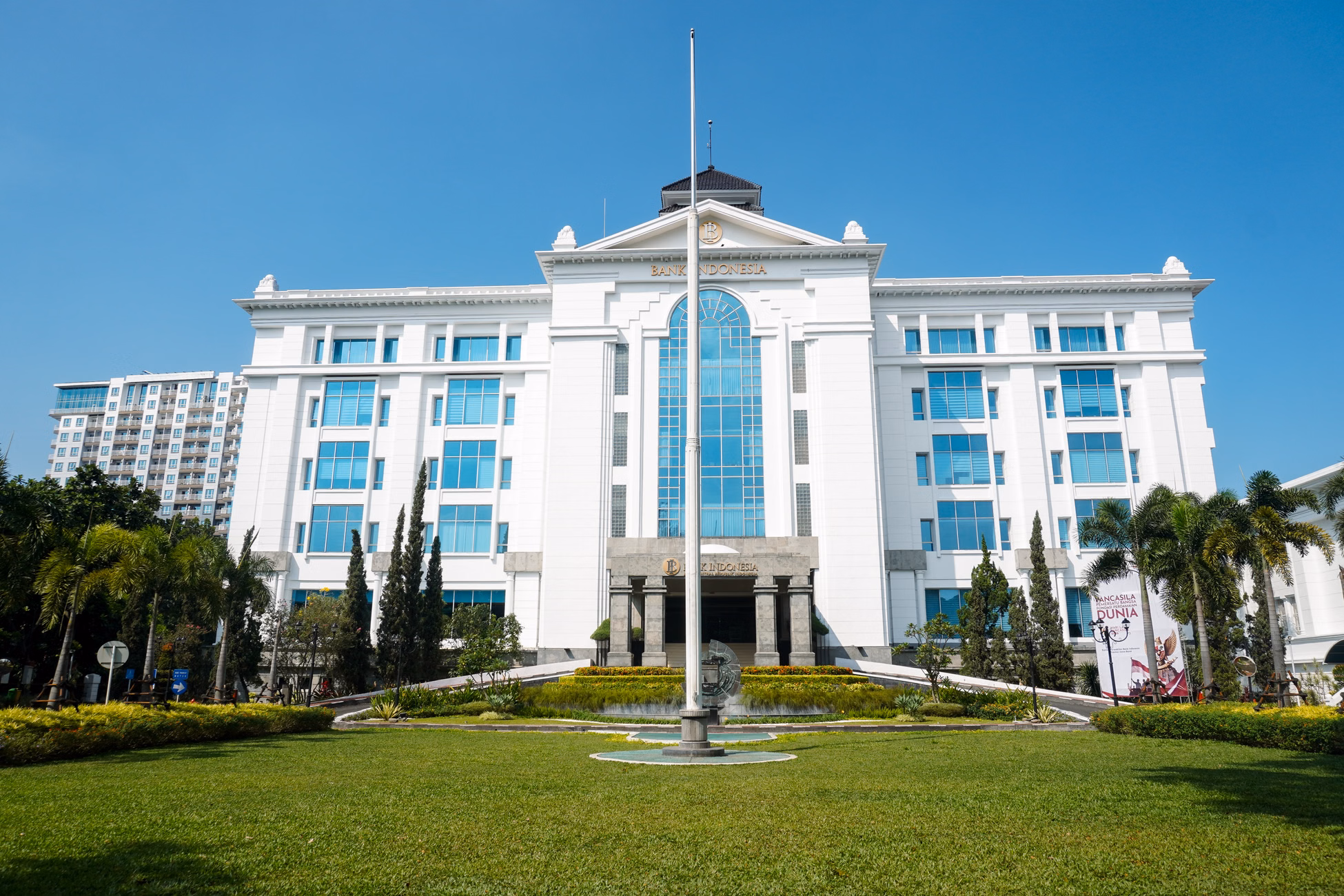 Front view of the elegant Bank Indonesia building in Bandung, showcasing colonial architecture on a bright day.