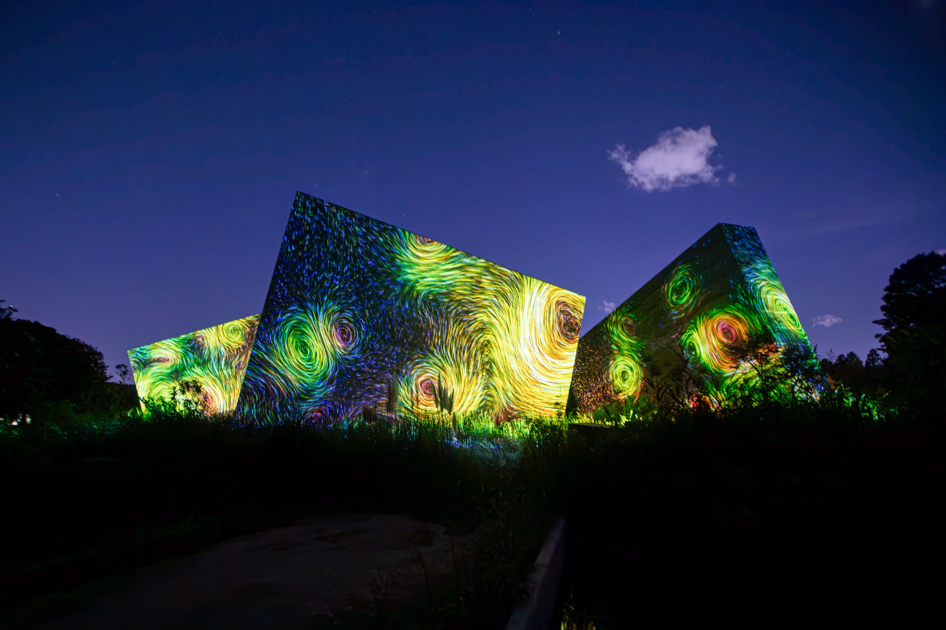 Dynamic light projections on modern architecture in Osaka at night.
