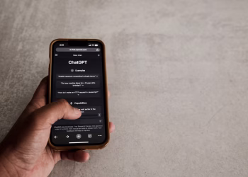Close-up of a hand interacting with ChatGPT on a smartphone, showcasing modern AI technology.