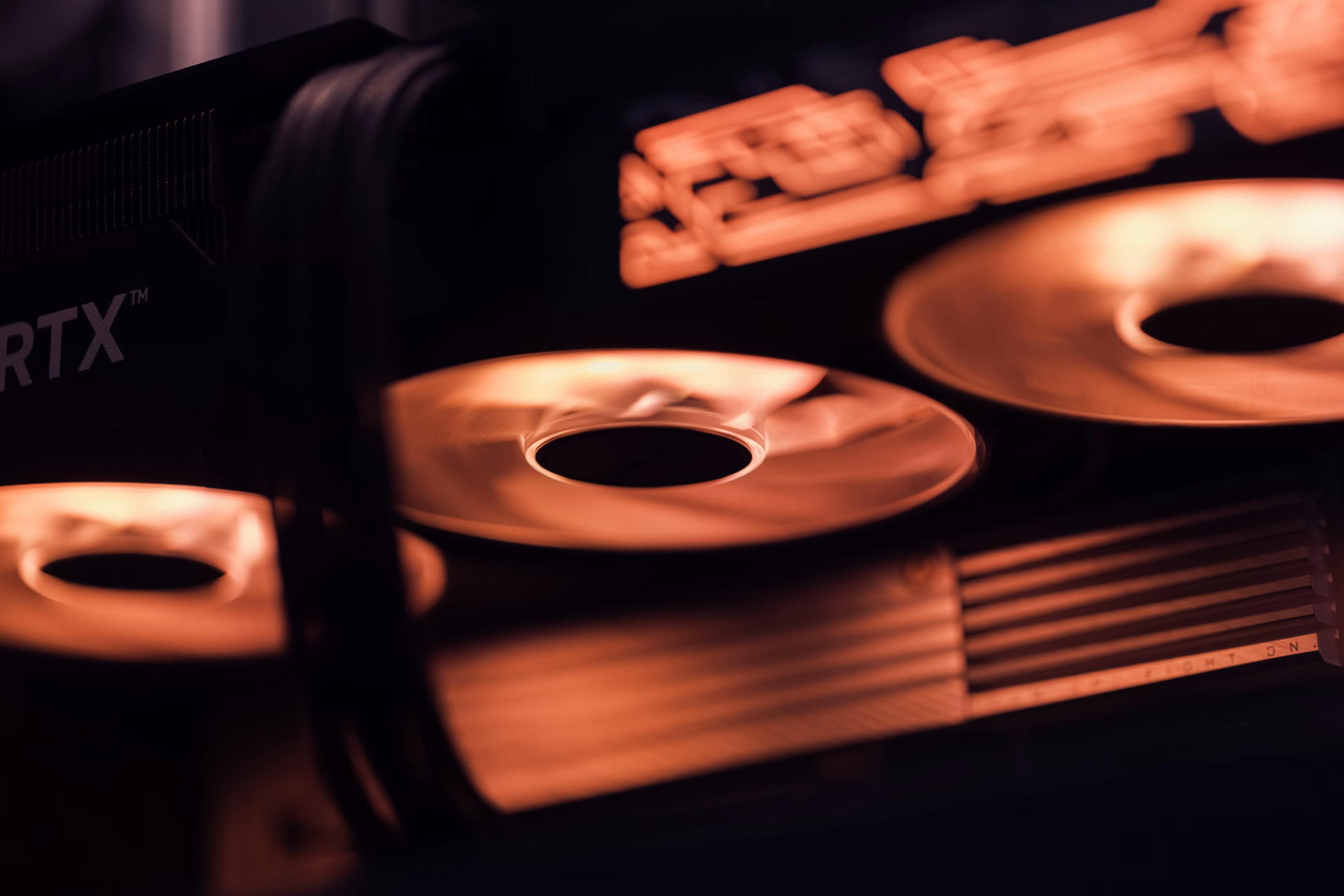 Dynamic close-up shot of illuminated gaming graphics card fans in red light, showcasing cutting-edge technology.
