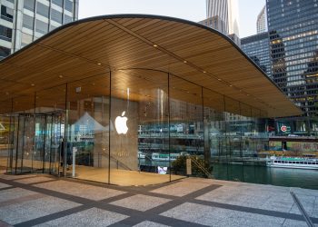 Exterior view of a modern Apple Store in downtown Chicago by the river, showcasing sleek glass architecture.