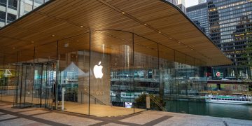 Exterior view of a modern Apple Store in downtown Chicago by the river, showcasing sleek glass architecture.