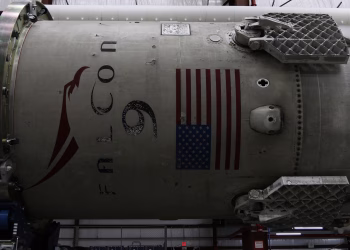 Fragment of modern spacecraft with printed flag of United States of America during assembly in rocket factory