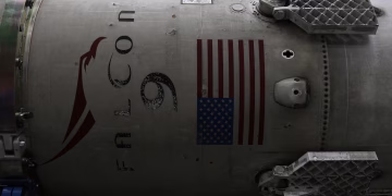 Fragment of modern spacecraft with printed flag of United States of America during assembly in rocket factory
