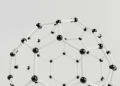Close-up of a geometric molecular structure model with black and white connections on a light background.