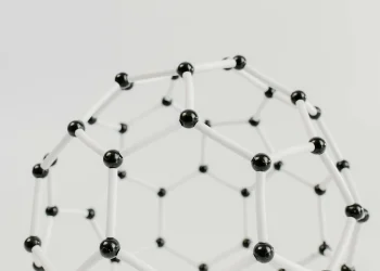 Close-up of a geometric molecular structure model with black and white connections on a light background.