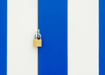 Padlock securing a blue and white striped door, symbolizing safety.
