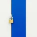 Padlock securing a blue and white striped door, symbolizing safety.