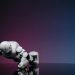 White robot doing push-ups on reflective surface, futuristic concept.