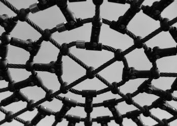 Black and white close-up of an intricate playground climb structure showcasing geometric patterns.