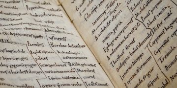 Detailed close-up of an ancient manuscript showcasing Latin text and calligraphy.
