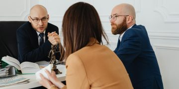 Professional discussion among lawyers in a modern office, focusing on legal matters.