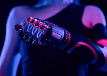 Close-up of a robotic prosthetic hand in neon lighting, symbolizing advanced technology.