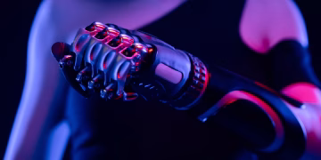 Close-up of a robotic prosthetic hand in neon lighting, symbolizing advanced technology.