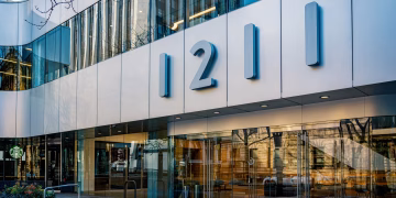 Contemporary architecture of office building facade with glass reflections in Portland, Oregon.