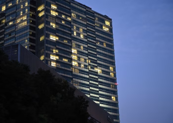 A tall building with lit windows against a dusky blue sky, conveying urban nightlife.
