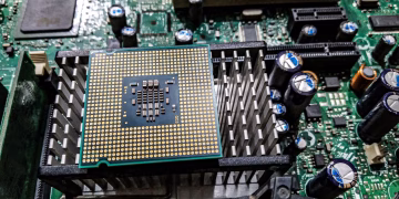Detailed view of a CPU on a motherboard showcasing electronic components and circuitry.