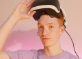 Caucasian man wearing and adjusting a VR headset in a minimalist indoor setting.