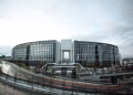 Contemporary government building with curved architecture in an urban setting at daytime.