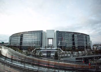 Contemporary government building with curved architecture in an urban setting at daytime.