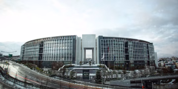 Contemporary government building with curved architecture in an urban setting at daytime.