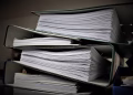 Close-up of stacked binders filled with documents for office or educational use.