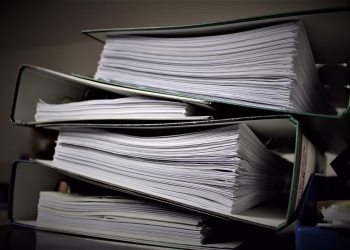 Close-up of stacked binders filled with documents for office or educational use.