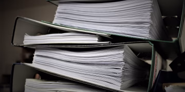 Close-up of stacked binders filled with documents for office or educational use.