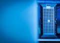 Close-up of a modern server unit in a blue-lit data center environment.