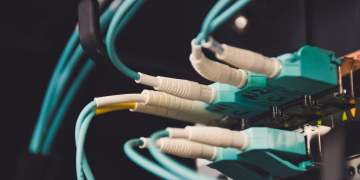 Detailed view of fiber optic cables and ports in a server room, showcasing connectivity.