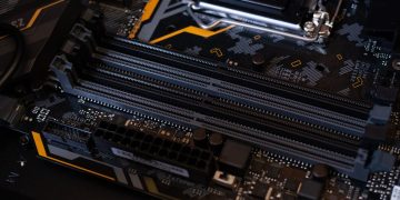 Detailed view of a computer motherboard showcasing RAM slots and electronic components.
