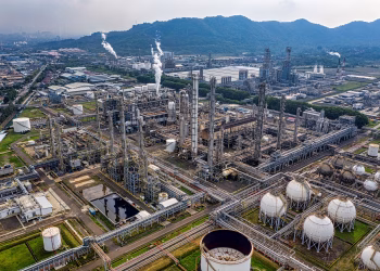 Aerial view of a large industrial oil refinery in Banten, Indonesia with storage tanks and pipelines.