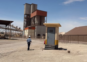 A cement manufacturing facility in Saudi Arabia with a worker on site under clear blue skies.
