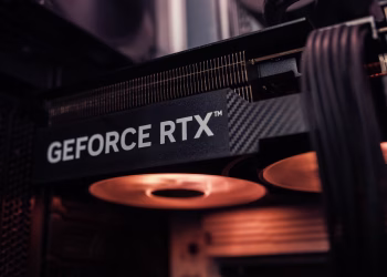GeForce RTX graphics card installed inside a PC, glowing under warm lighting.