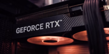 GeForce RTX graphics card installed inside a PC, glowing under warm lighting.
