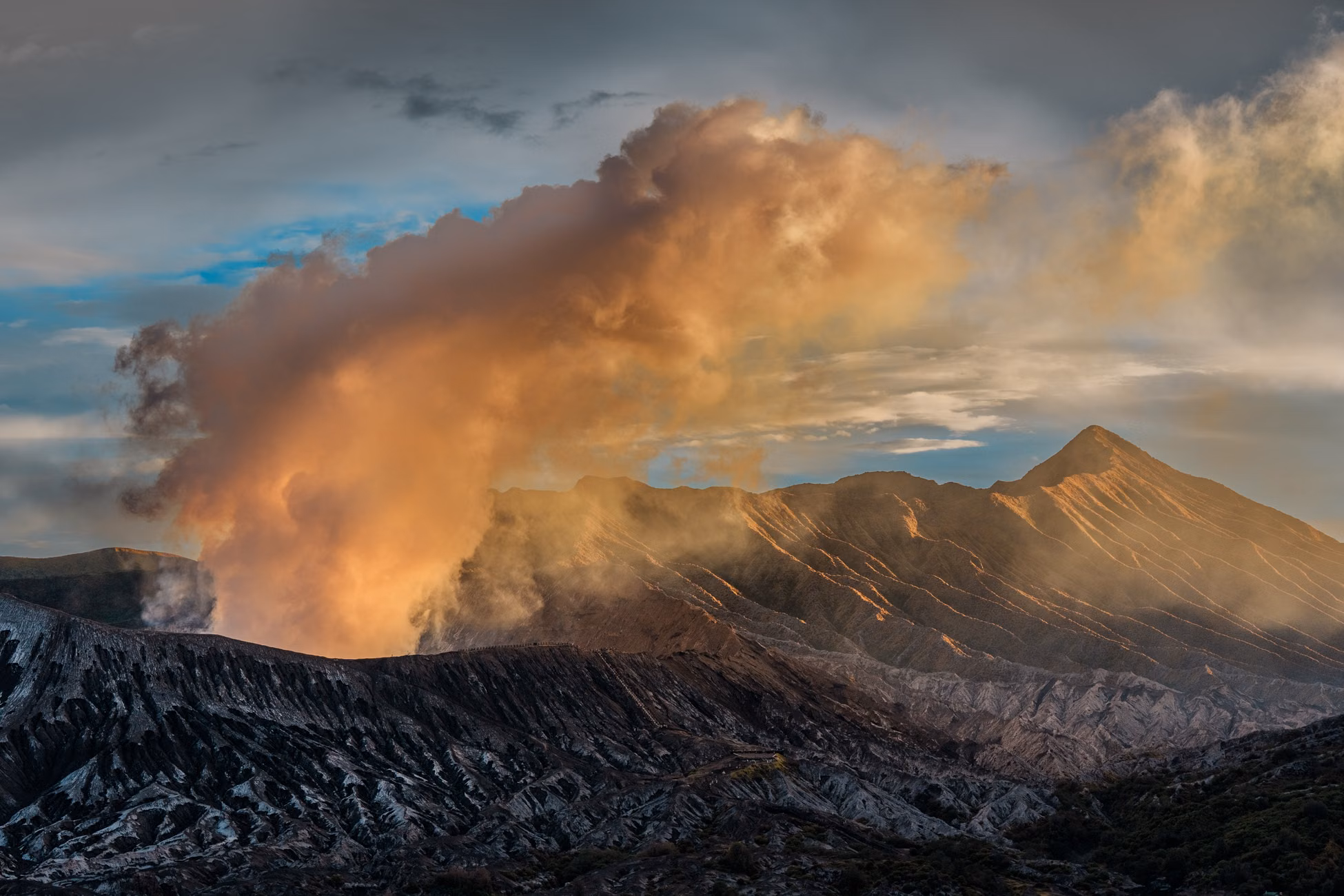 Stunning view of Mount Bromo at sunrise with volcanic smoke rising in East Java, Indonesia.