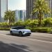 Image of a car speeding on a road in the sunshine.