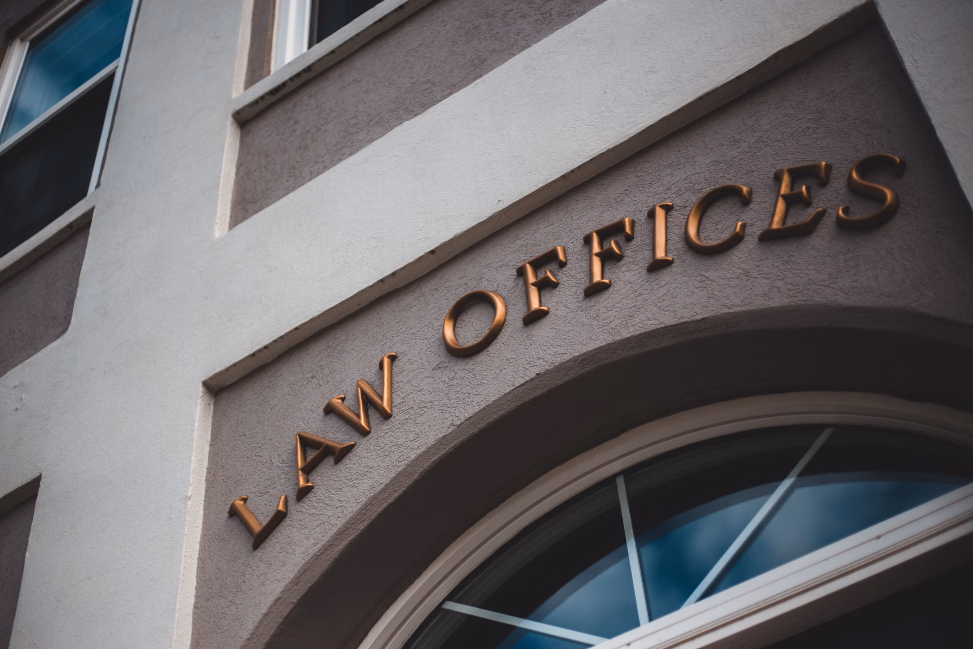 Low angle view of a modern law office exterior with elegant facade and arched entrance.