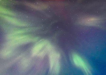 Vibrant northern lights create a mesmerizing display in the dark night sky.