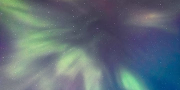 Vibrant northern lights create a mesmerizing display in the dark night sky.
