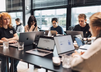 Focused team engaged in discussion and planning at a modern office setting.