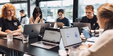 Focused team engaged in discussion and planning at a modern office setting.