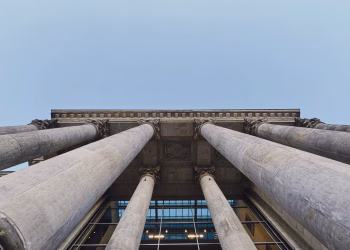 Upward angle of Berlin building showcasing classic pillars and architectural symmetry.