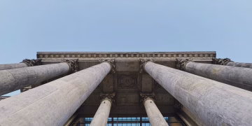 Upward angle of Berlin building showcasing classic pillars and architectural symmetry.