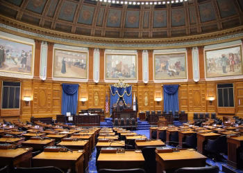 A beautiful view of the Massachusetts State House chamber with elegant decor and empty seating.