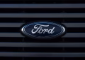 Detailed view of a Ford emblem mounted on a vehicle grille, showcasing modern design.