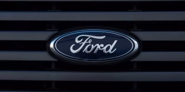 Detailed view of a Ford emblem mounted on a vehicle grille, showcasing modern design.