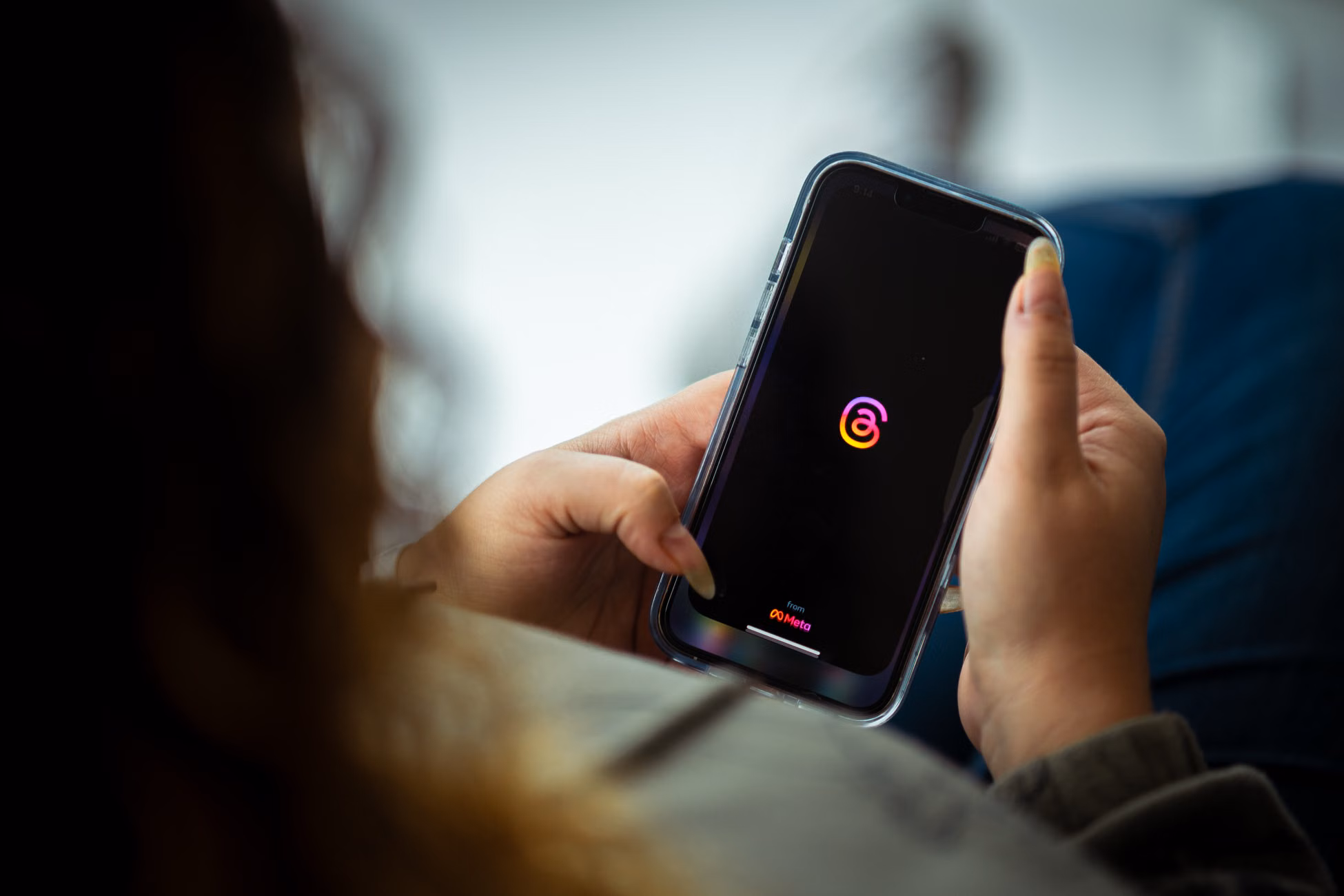 Close-up of a person holding a smartphone with a social media app open