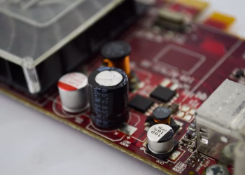 Detailed macro shot of a circuit board highlighting capacitors, chips, and circuits.